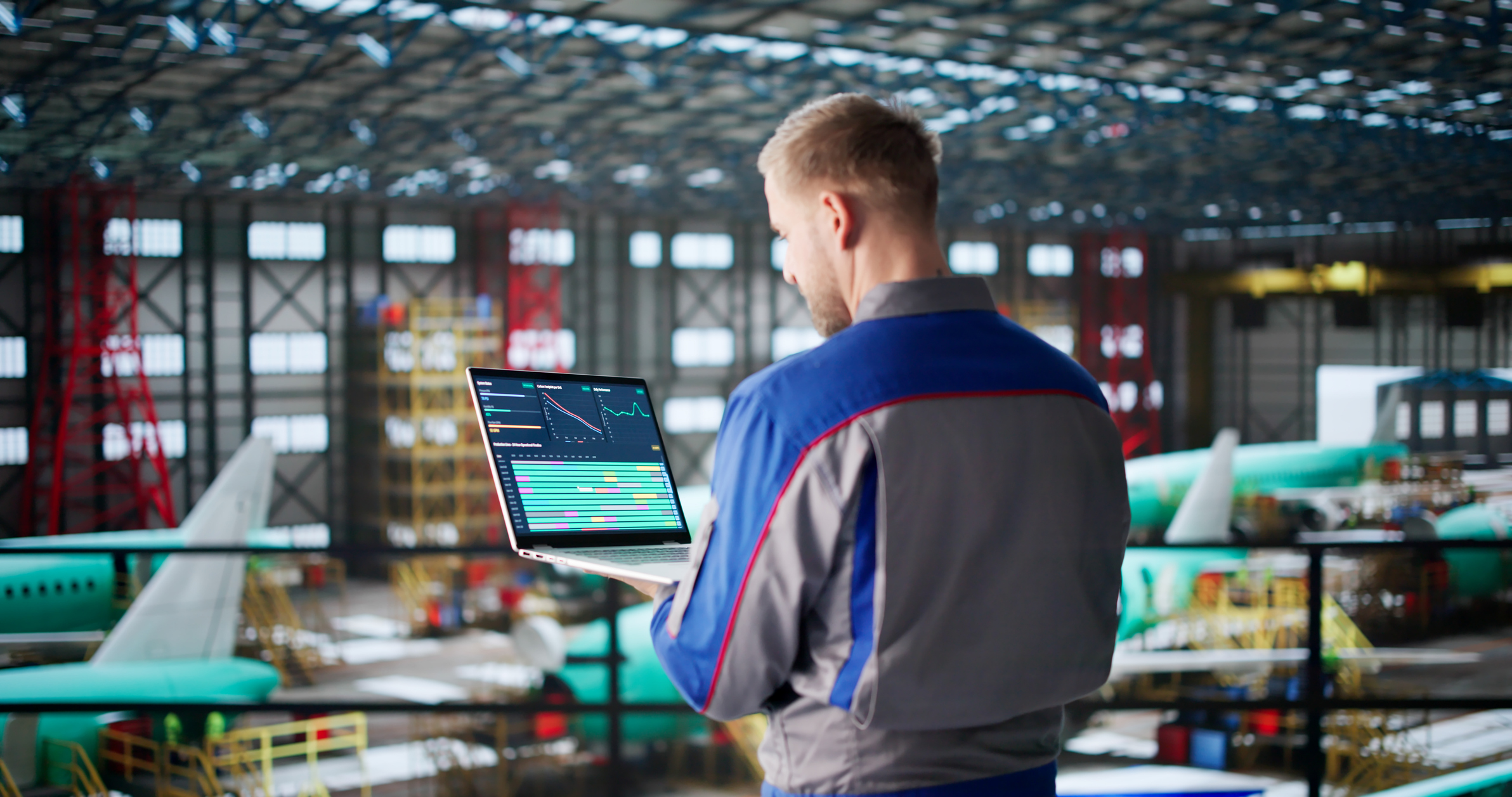 Aircraft maintenance engineer reviewing analytics dashboard in hangar
