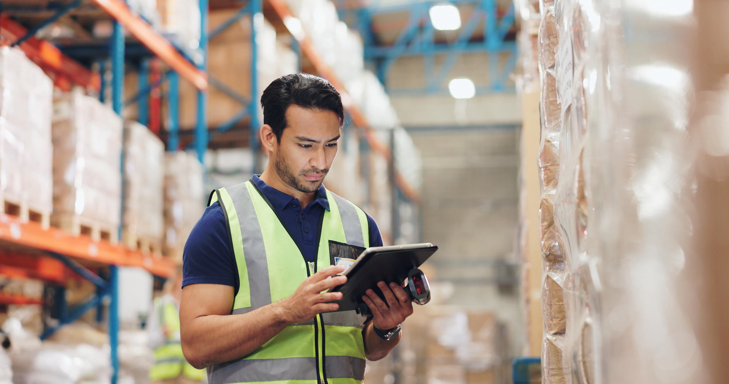 Warehouse worker using tablet to track inventory