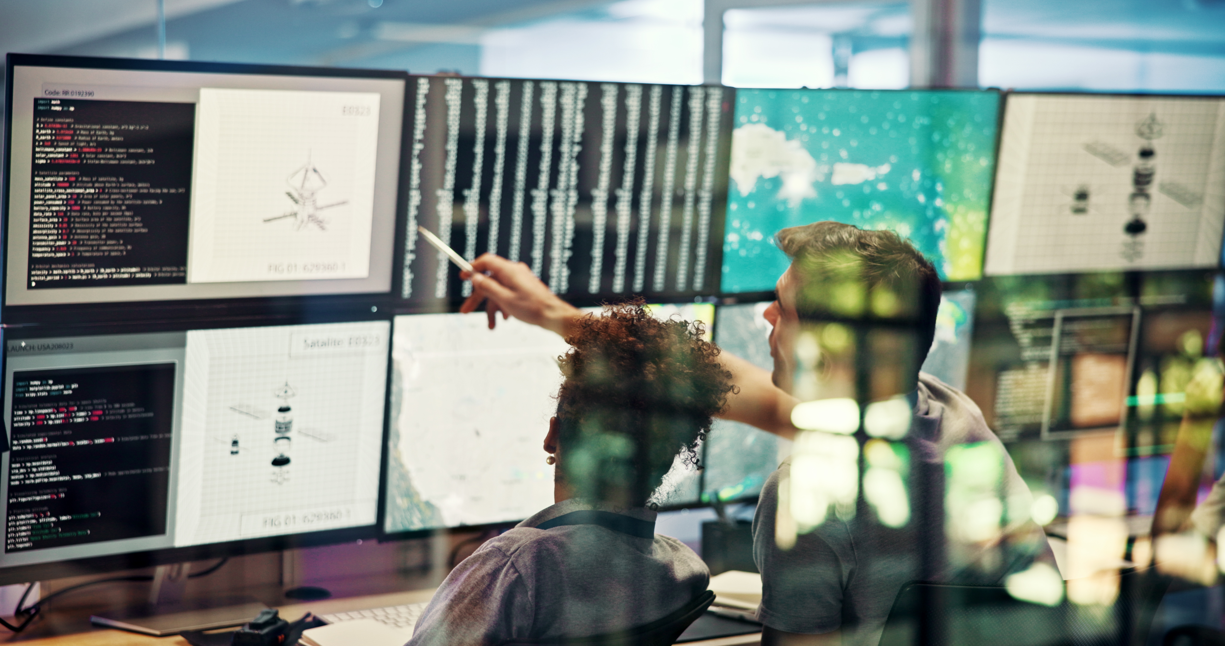 Operations center with analysts monitoring multiple screens showing satellite data and maps